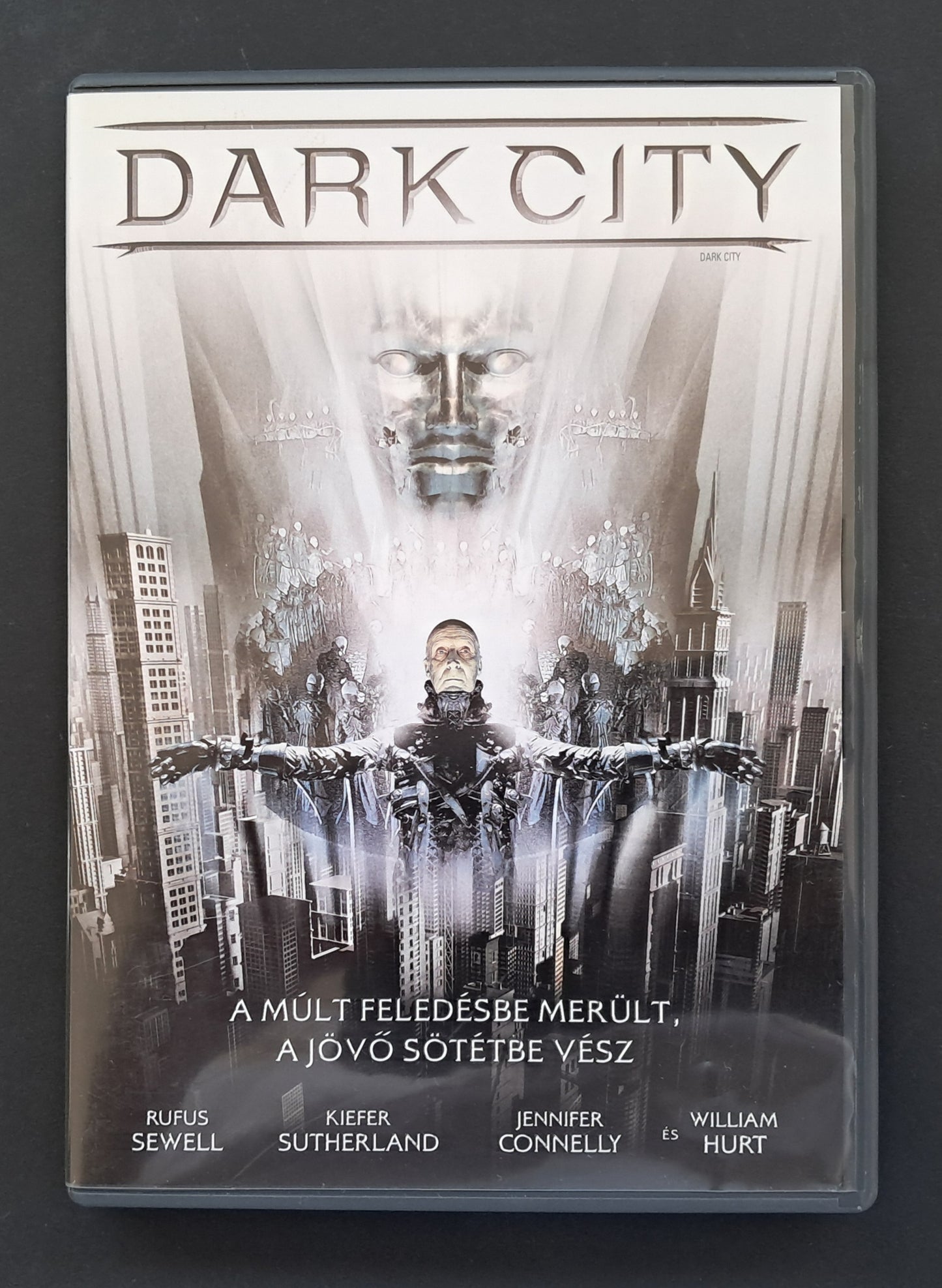 DVD cover of 'Dark City' with a futuristic cityscape and central figure.